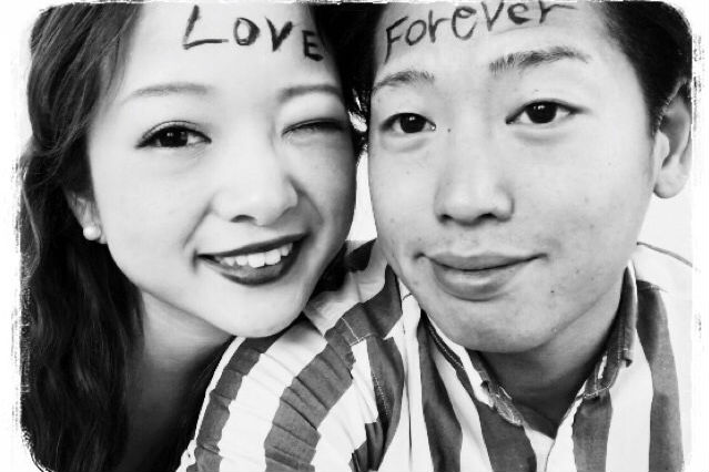 おでこに「LOVE」と書かれた新婦とおでこに「FOREVER]と書かれた新郎のアップの写真